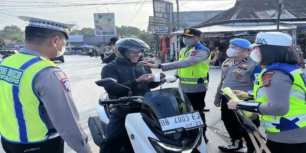 Kapolres Toba Turun ke Jalan Atur Lalu Lintas Sekaligus Bagikan Masker ke Warga